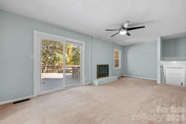 a view of empty room with a fireplace and fan