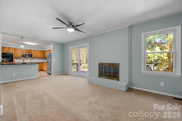 a view of an empty room with a fireplace and a window