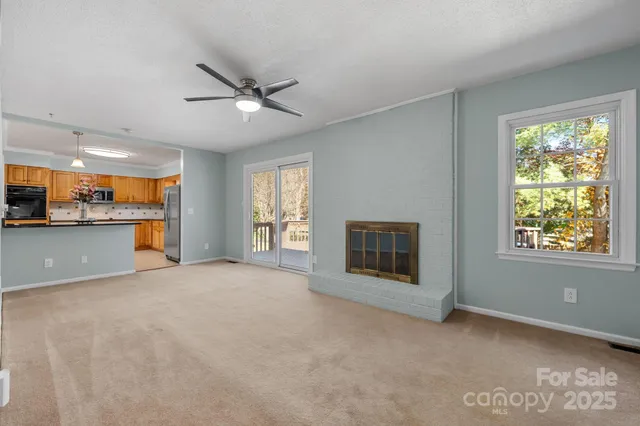 an empty room with a window and a fan