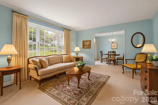 a living room with furniture a table and a large window