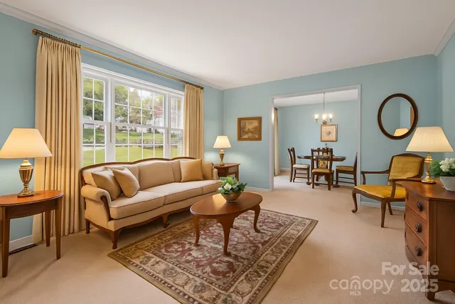 a living room with furniture a table and a large window