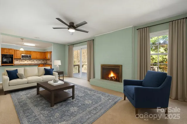 a living room with furniture a fireplace and a floor to ceiling window