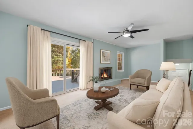 a living room with furniture a fireplace and a floor to ceiling window