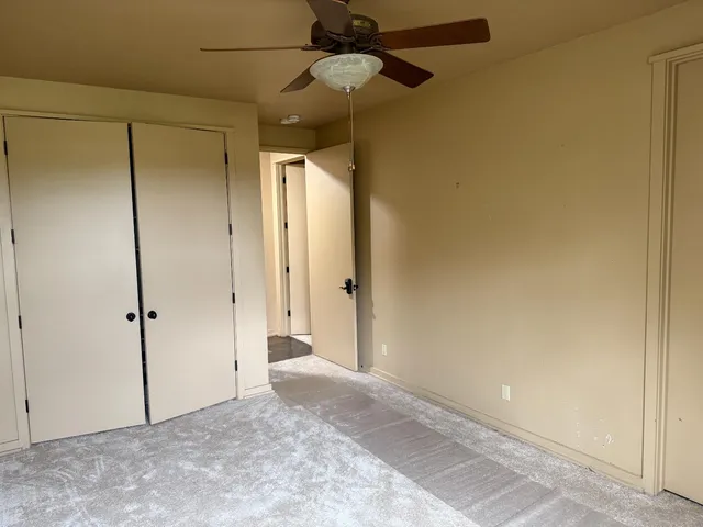 a view of a hallway with a chandelier fan