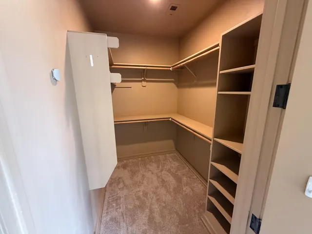 a view of walk in closet with empty racks