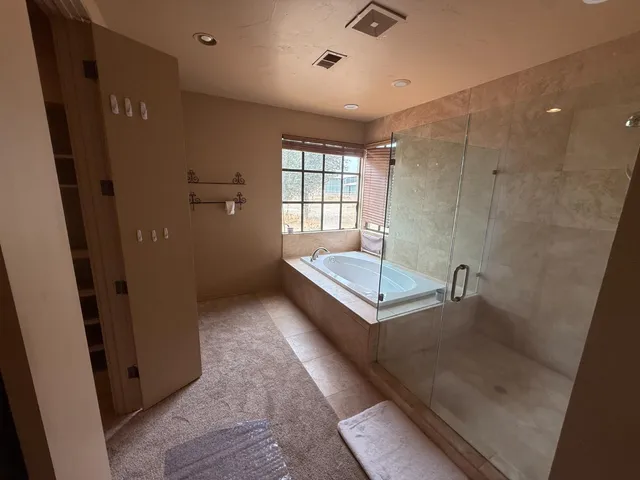 a bathroom with a tub shower vanity and a sink