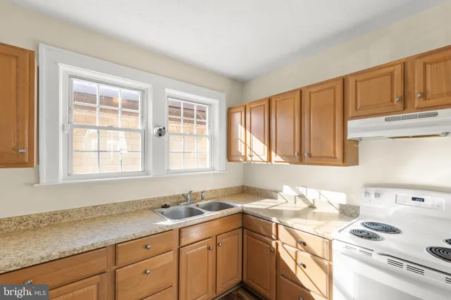 a kitchen with a sink stove top oven and cabinets