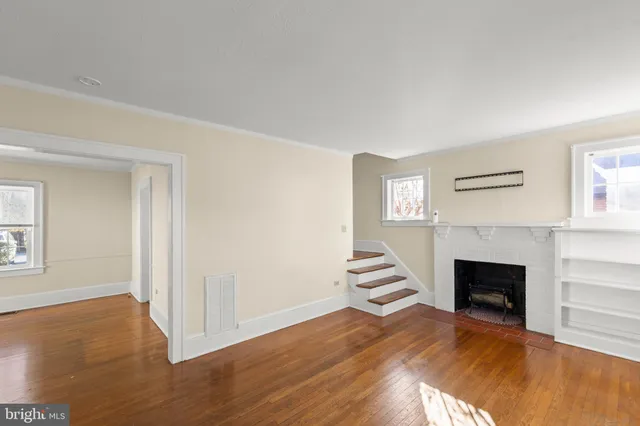 a view of empty room with wooden floor and fireplace