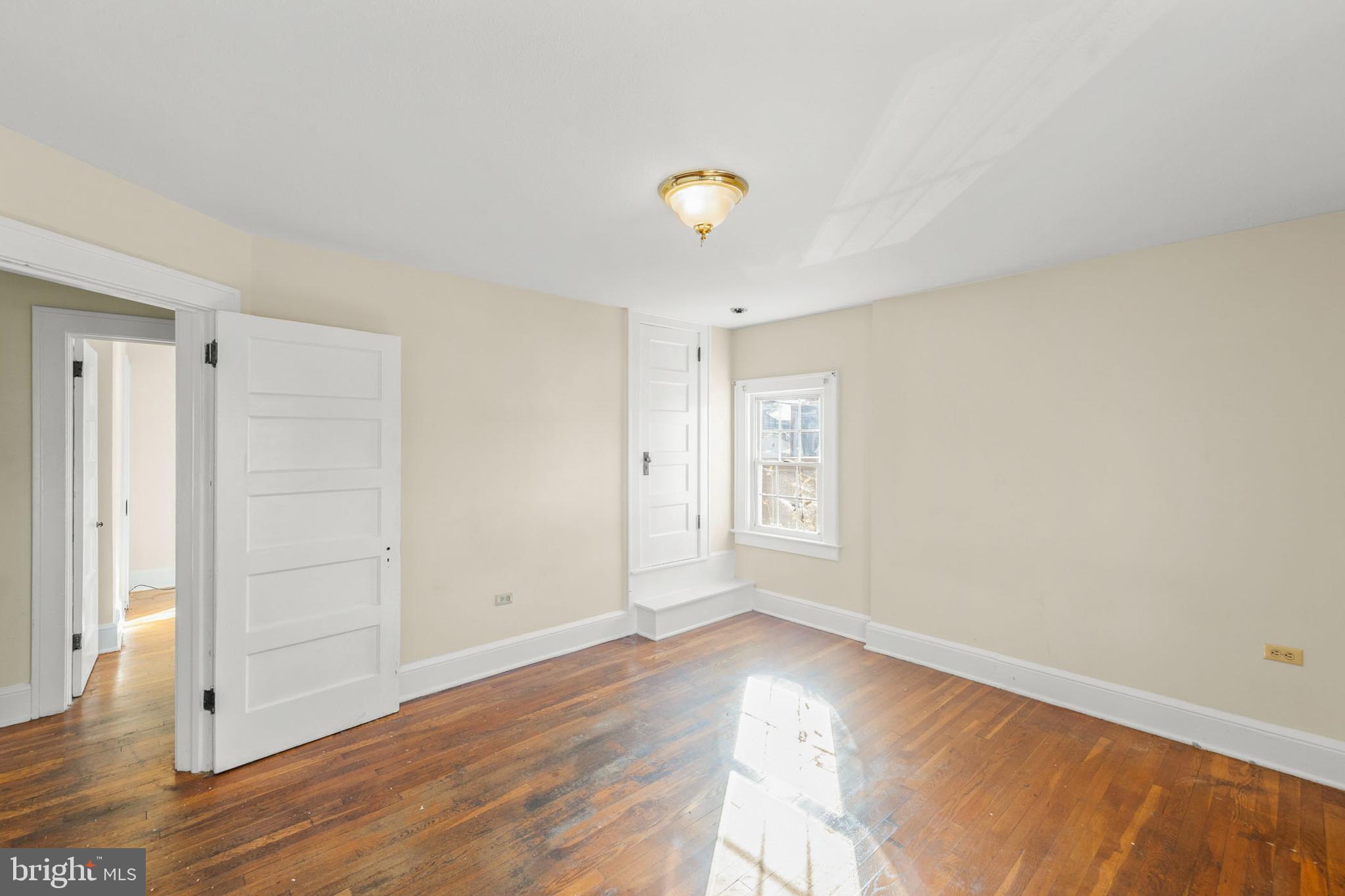675 Berryville Avenue Winchester, VA 22601 - Photo 23 of 32 an empty room with wooden floor and windows with curtains