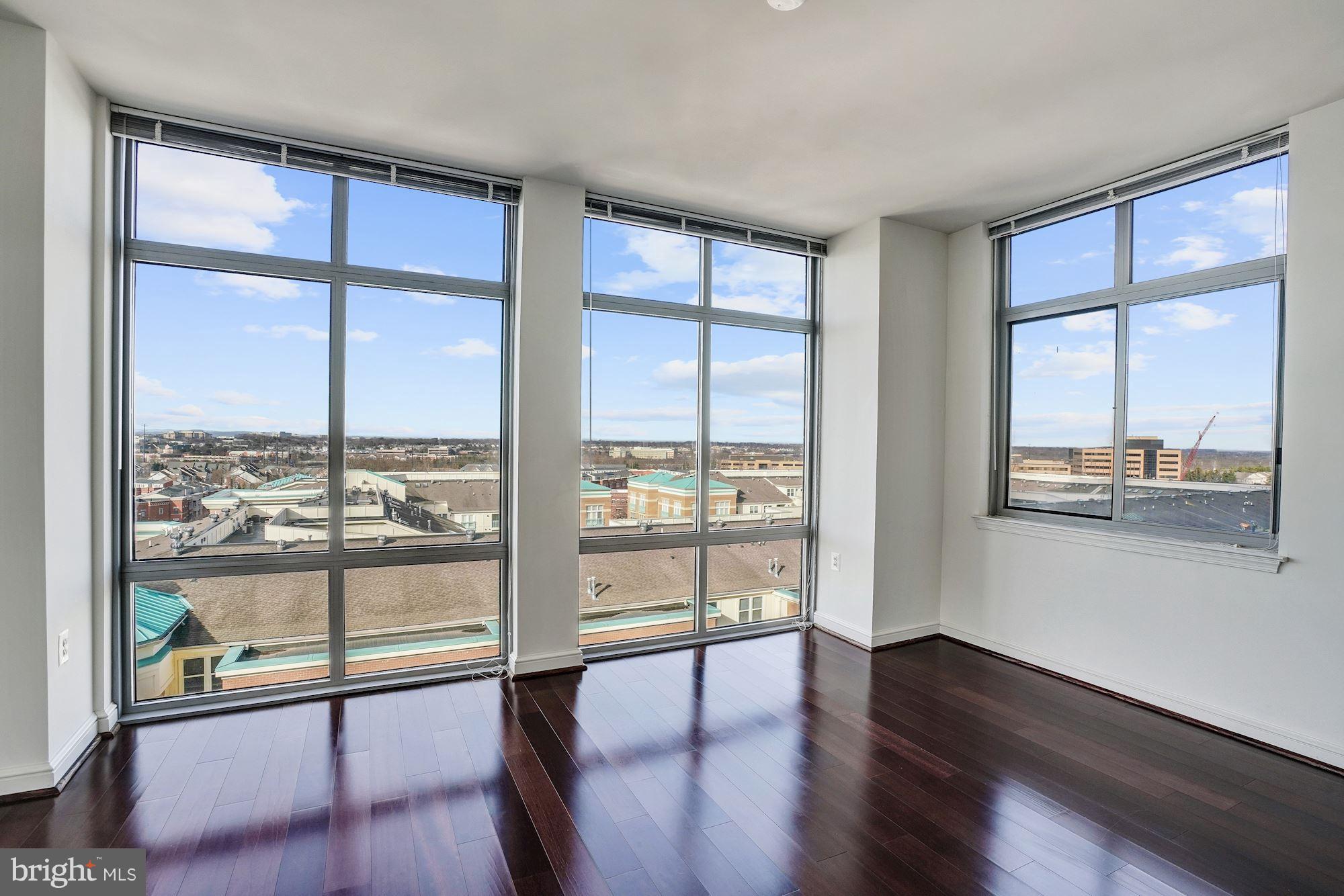 11990 Market Street, Unit 713 Reston, VA 20190 - Photo 12 of 30 a view of an empty room with wooden floor and a window