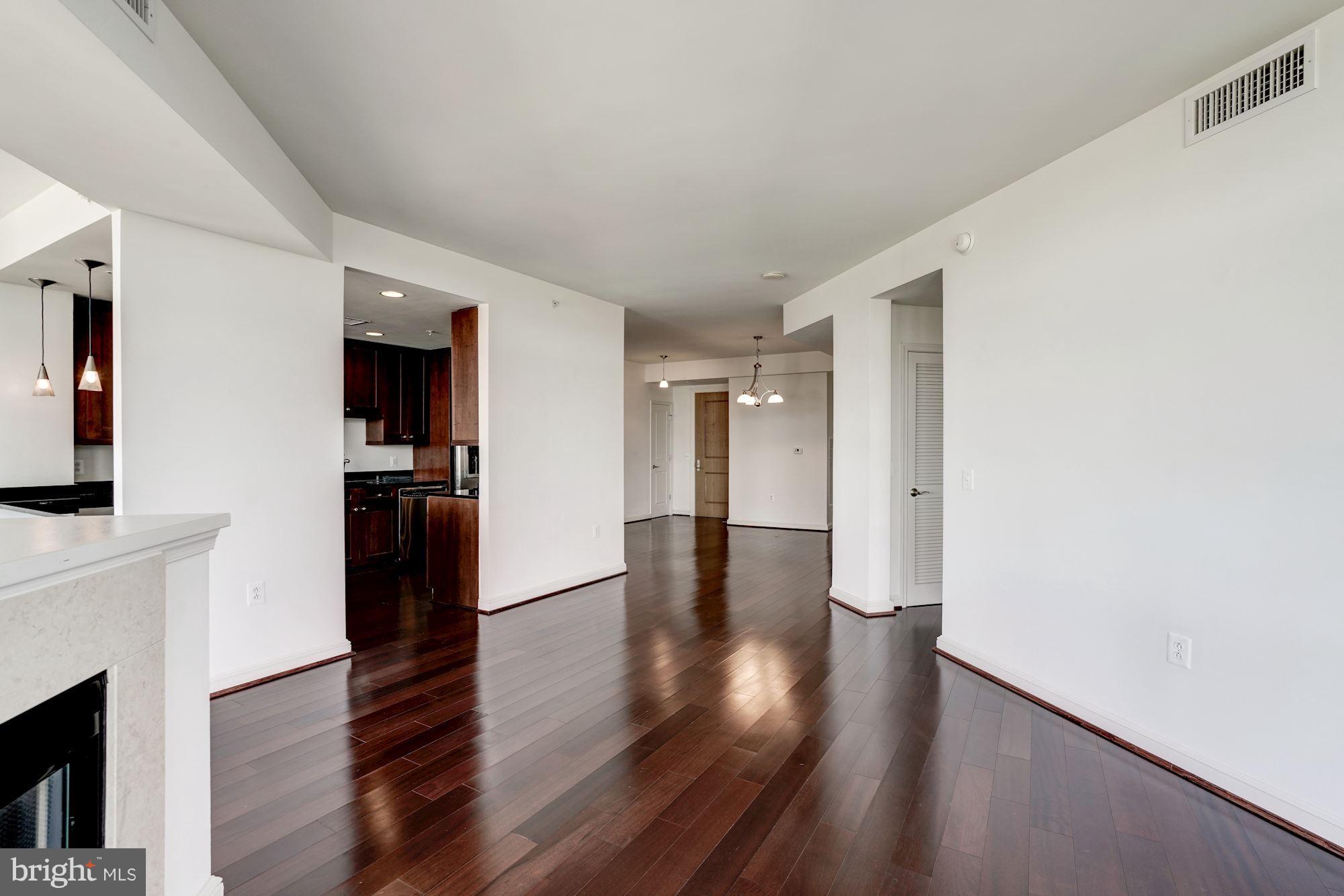 11990 Market Street, Unit 713 Reston, VA 20190 - Photo 17 of 30 a view of a hallway with wooden floor and a living room