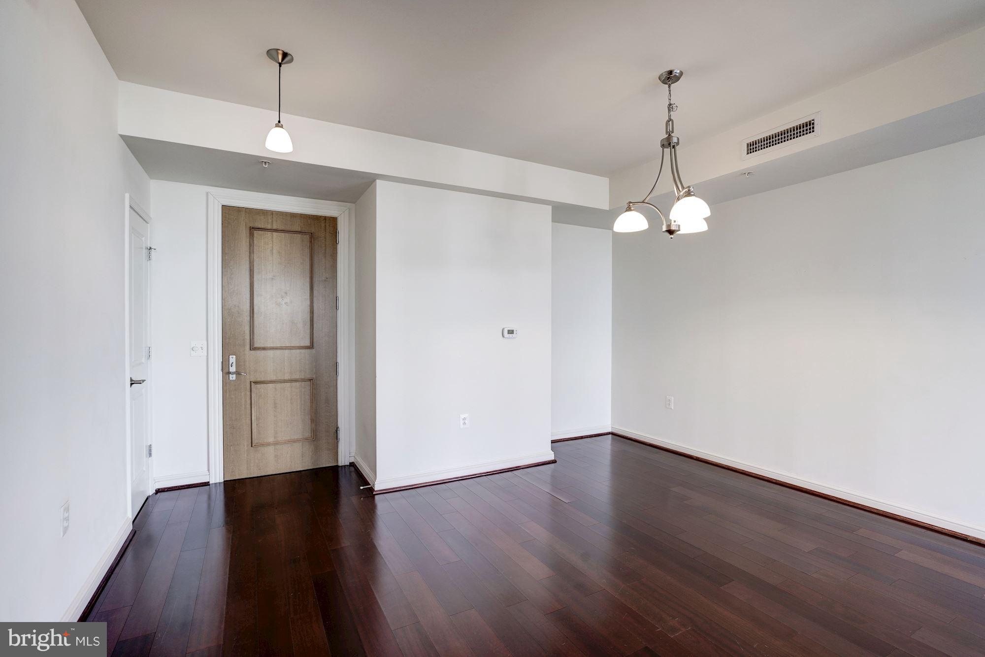 11990 Market Street, Unit 713 Reston, VA 20190 - Photo 5 of 30 a view of an empty room with wooden floor