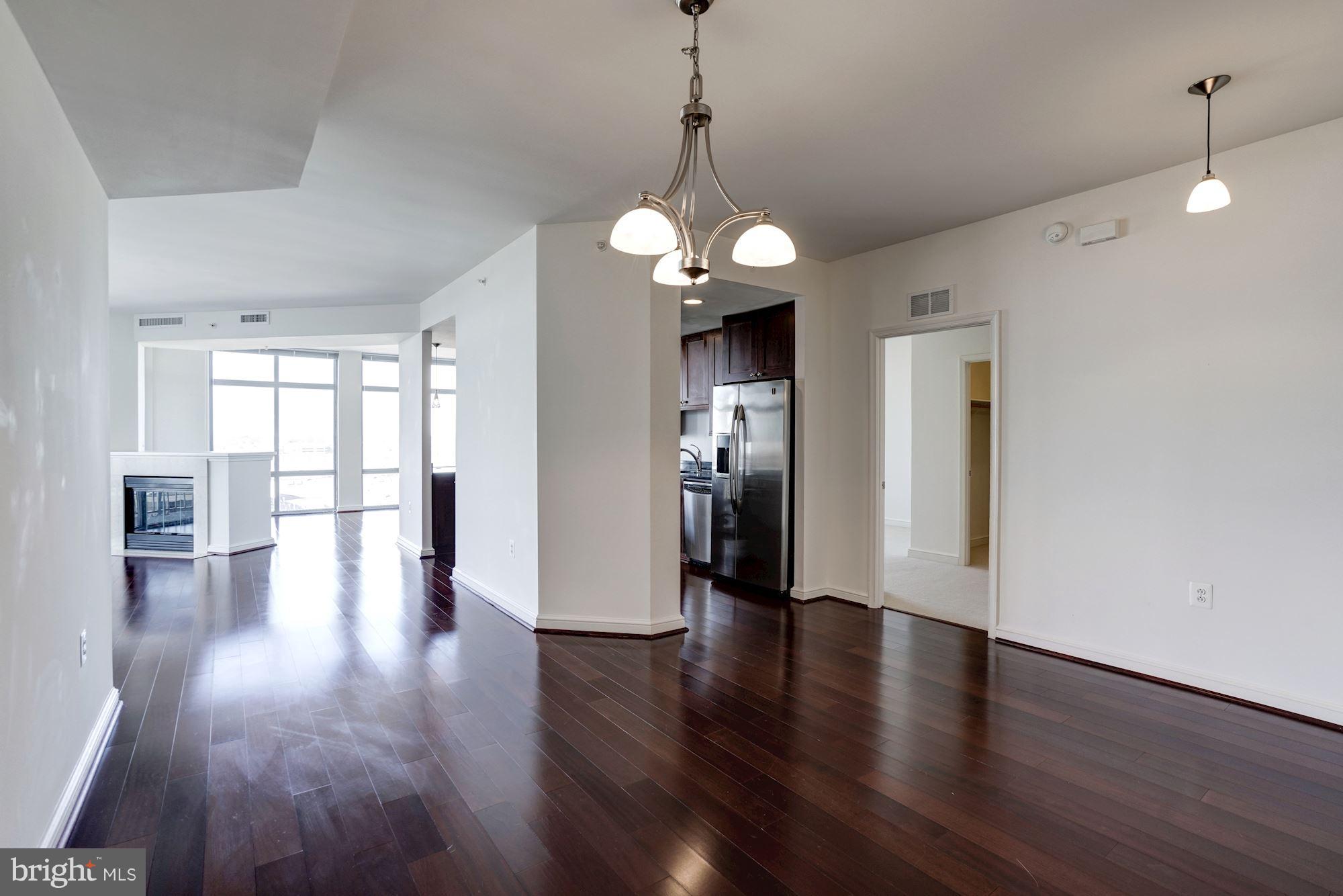 11990 Market Street, Unit 713 Reston, VA 20190 - Photo 6 of 30 a view of a big room with wooden floor windows and cabinet