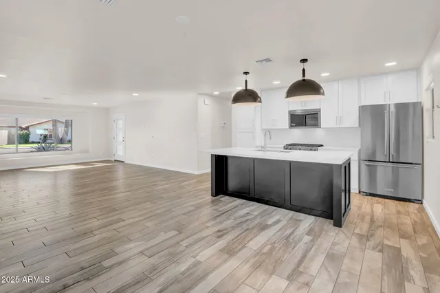 a kitchen with stainless steel appliances a sink and a refrigerator