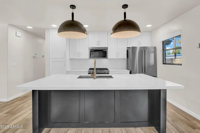 a kitchen with a sink a refrigerator and a stove
