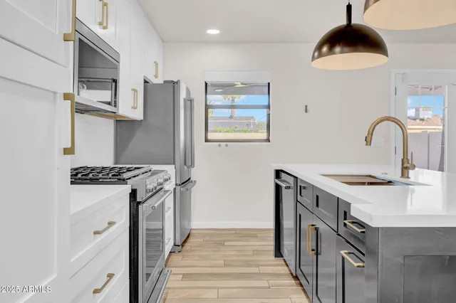 a kitchen with stainless steel appliances granite countertop a stove and a sink