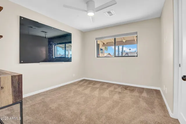 an empty room with windows and cabinet