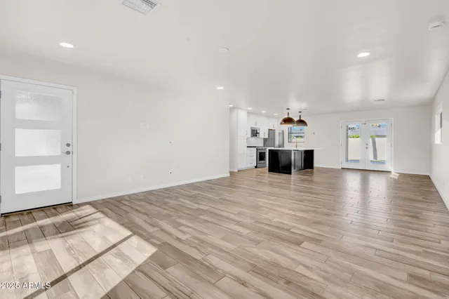 a view of empty room with wooden floor