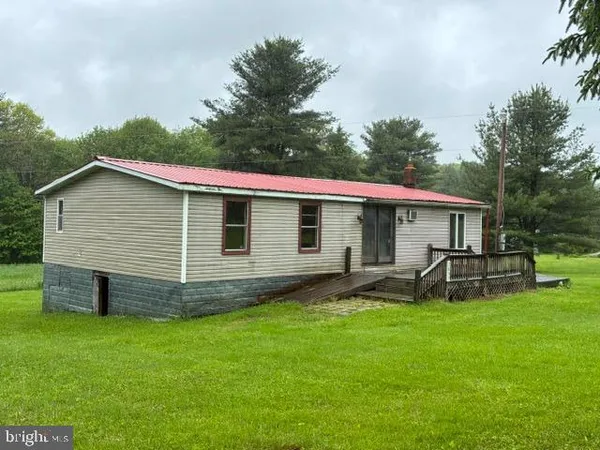 a view of a house with a yard and sitting area