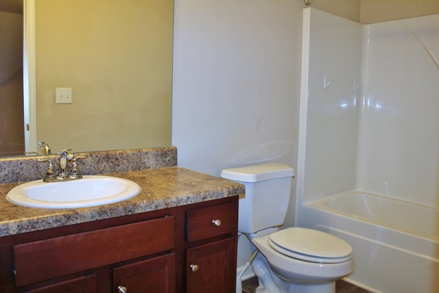 2141 Lee Road Phenix City, AL 36870 - Photo 20 of 24 a bathroom with a granite countertop sink toilet and a mirror