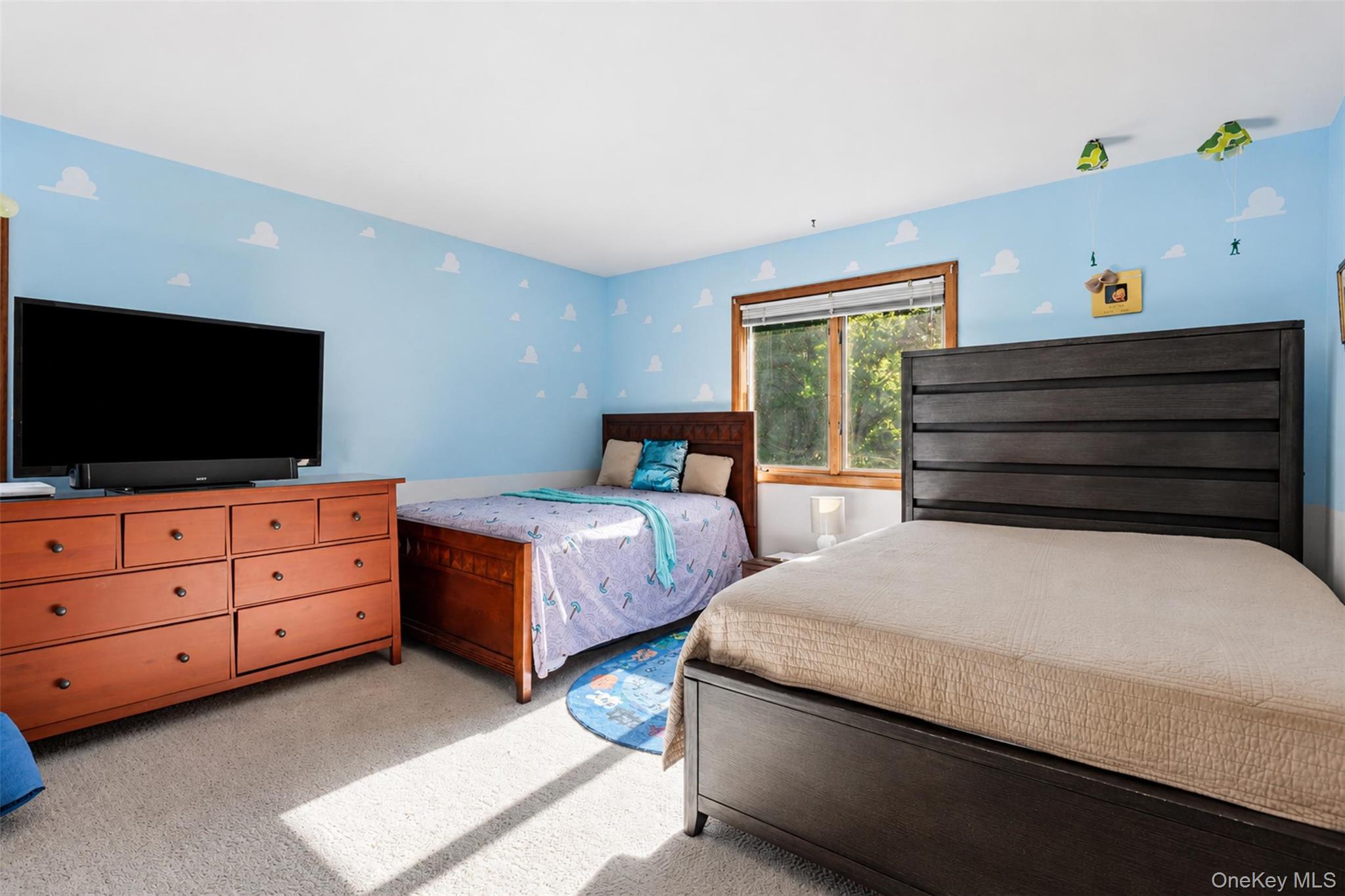 985 Craigville Road Chester, NY 10918 - Photo 21 of 36 Bedroom featuring light blue walls with cloud detailing, a large window with natural wood trim, and neutral carpet flooring