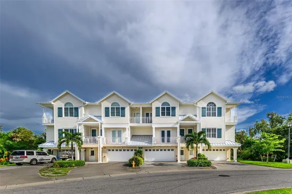 a front view of residential houses with yard and parking space