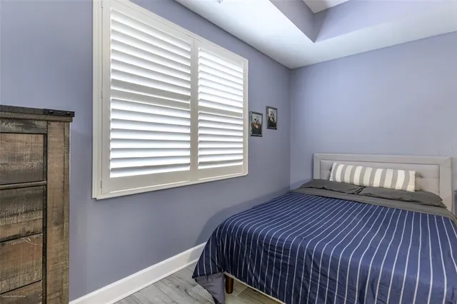 a bedroom with bed and wooden floor