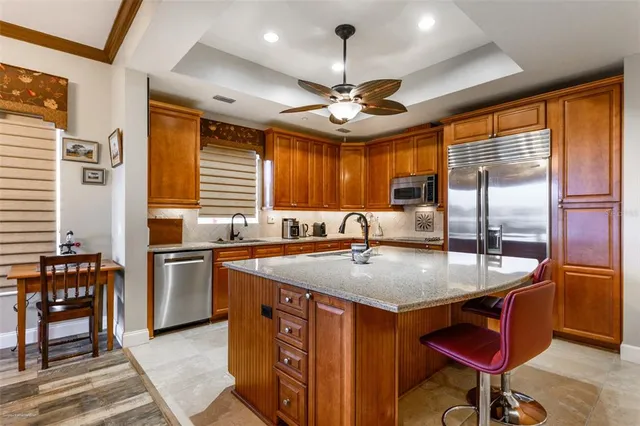 a kitchen with cabinets a counter space dining table and stainless steel appliances