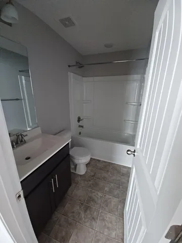 a bathroom with a sink a toilet a tub and shower