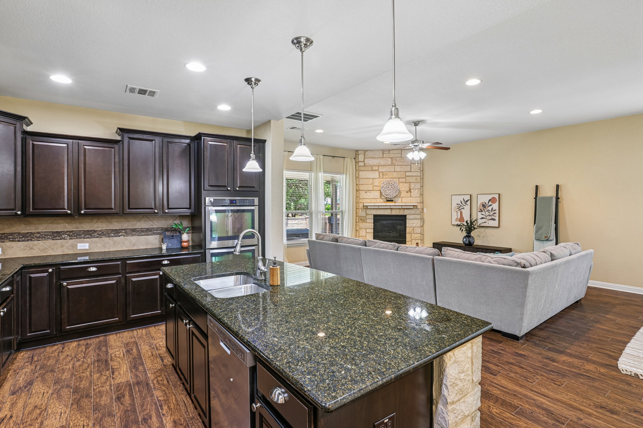 1924 Granite Springs Road Leander, TX 78641 - Photo 11 of 36 An inviting open-concept layout connects a well-appointed kitchen to a cozy living area with a stone fireplace.