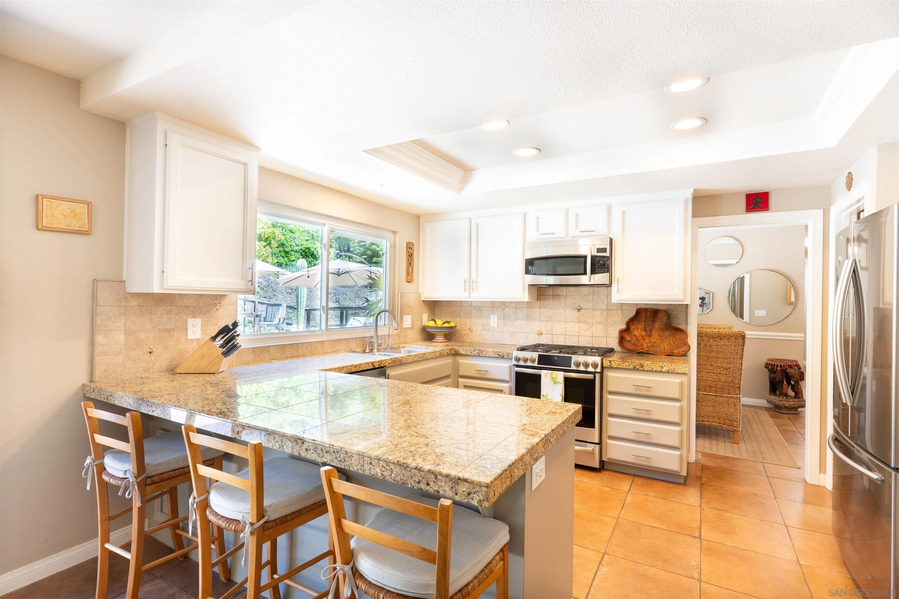1045 Capra Way Fallbrook, CA 92028 - Photo 13 of 44 a kitchen with stainless steel appliances granite countertop a stove top oven a refrigerator a sink and white cabinets with island