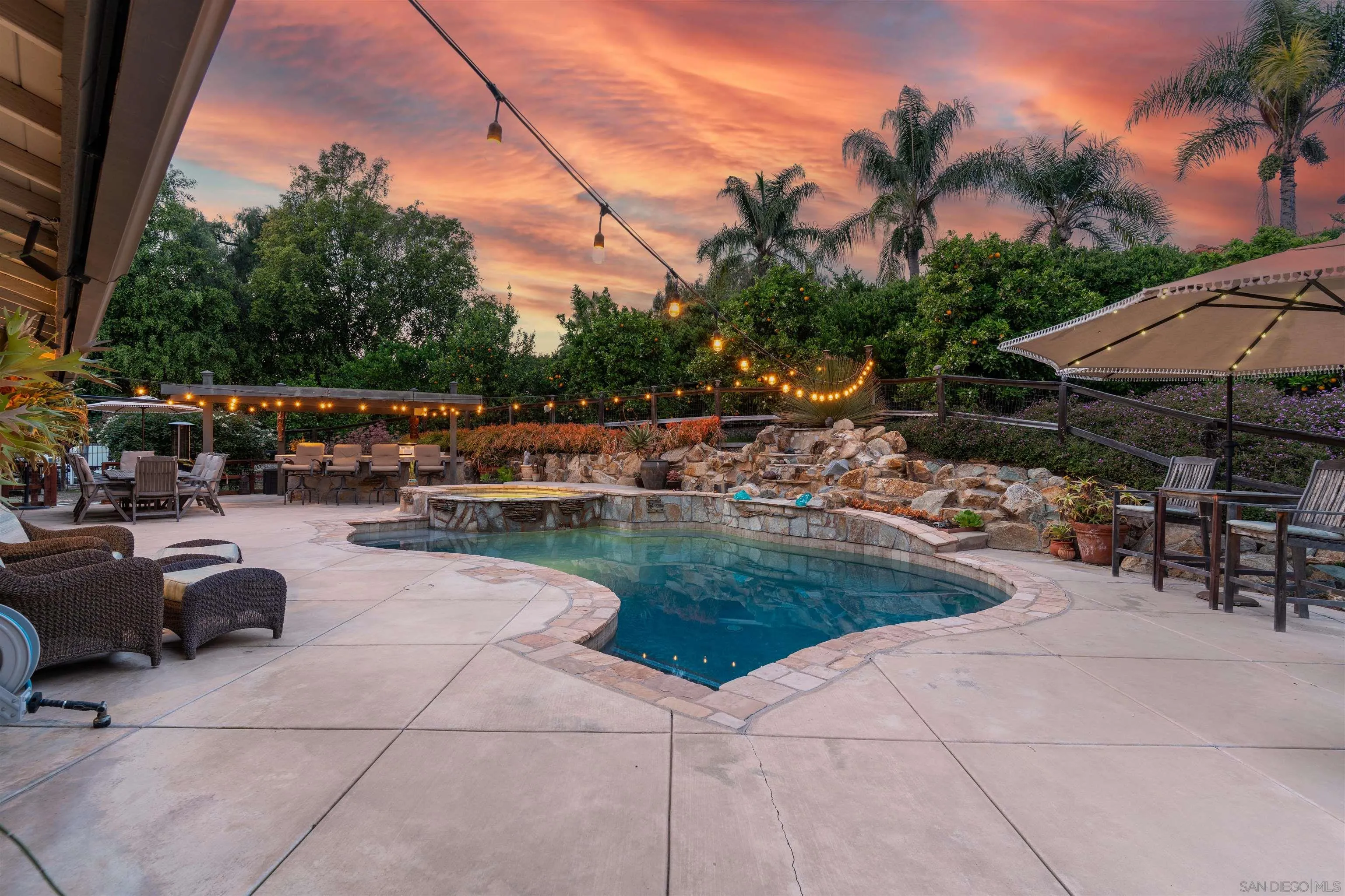 1045 Capra Way Fallbrook, CA 92028 - Photo 2 of 44 a view of a patio with dining table and chairs under an umbrella