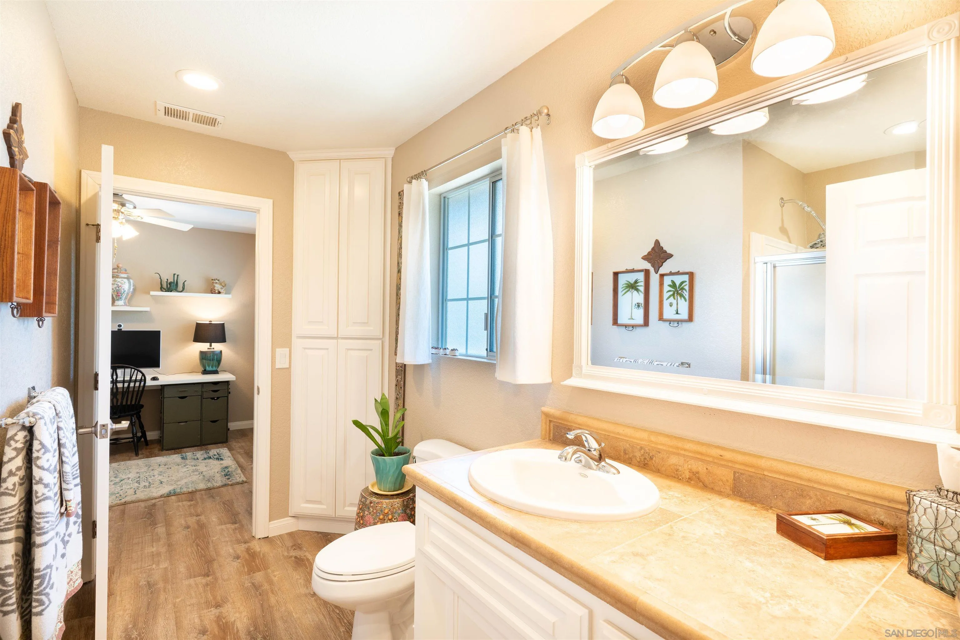 1045 Capra Way Fallbrook, CA 92028 - Photo 21 of 44 a bathroom with a granite countertop sink and a large mirror