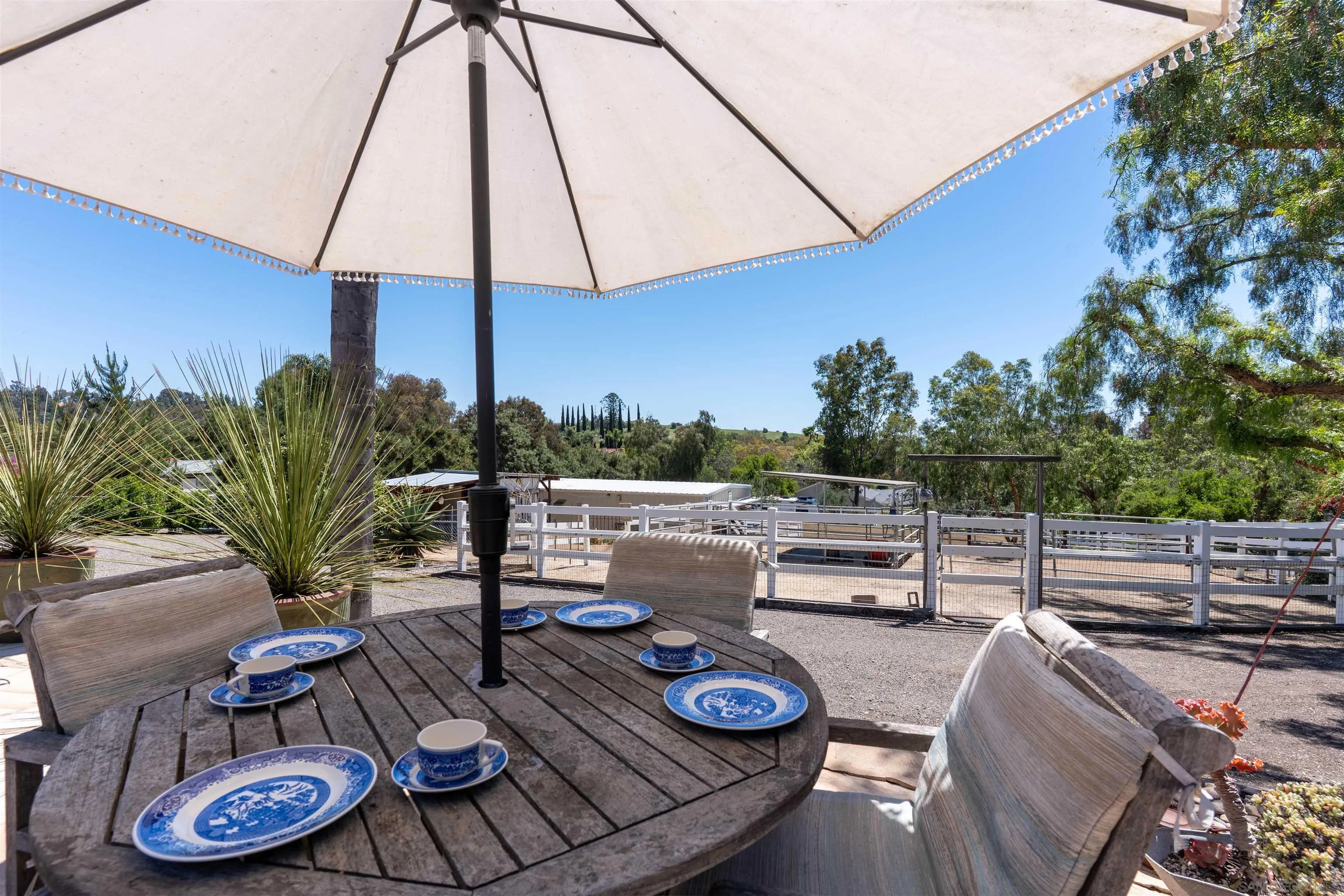 1045 Capra Way Fallbrook, CA 92028 - Photo 36 of 44 a view of a patio with chairs and table under an umbrella