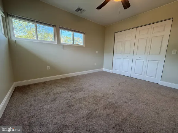an empty room with chandelier fan