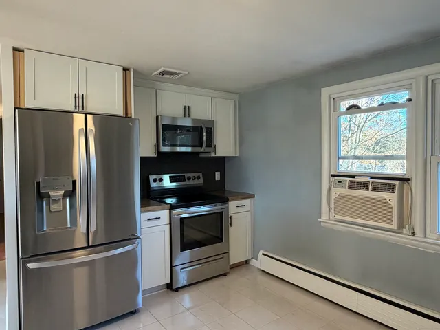 a view of a hallway with wooden floor and stairs