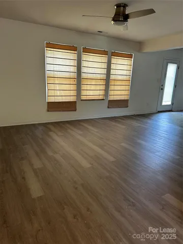 a view of an empty room with kitchen and a sink