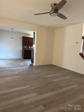 an empty room with windows and ceiling fan