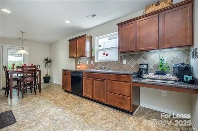 a kitchen with granite countertop a refrigerator stove top oven and sink