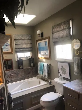 a bathroom with a granite countertop sink mirror vanity and toilet