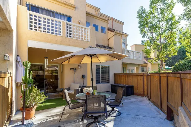 a view of a chair and table in the patio in front of house