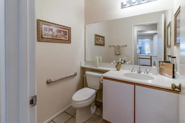 a bathroom with a granite countertop sink mirror vanity and toilet