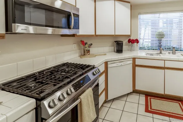 a kitchen with stainless steel appliances a sink a stove and cabinets