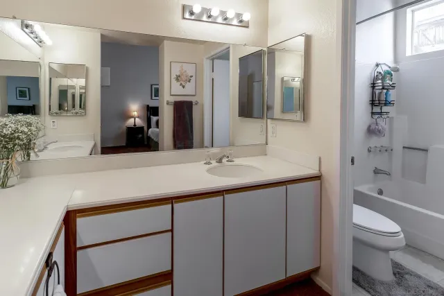 a bathroom with a granite countertop sink toilet and shower