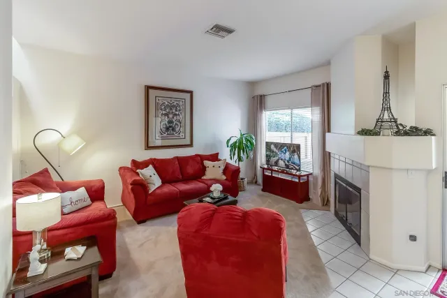 a living room with furniture a fireplace and a window