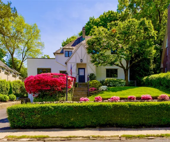 a front view of a house with a yard and fountain