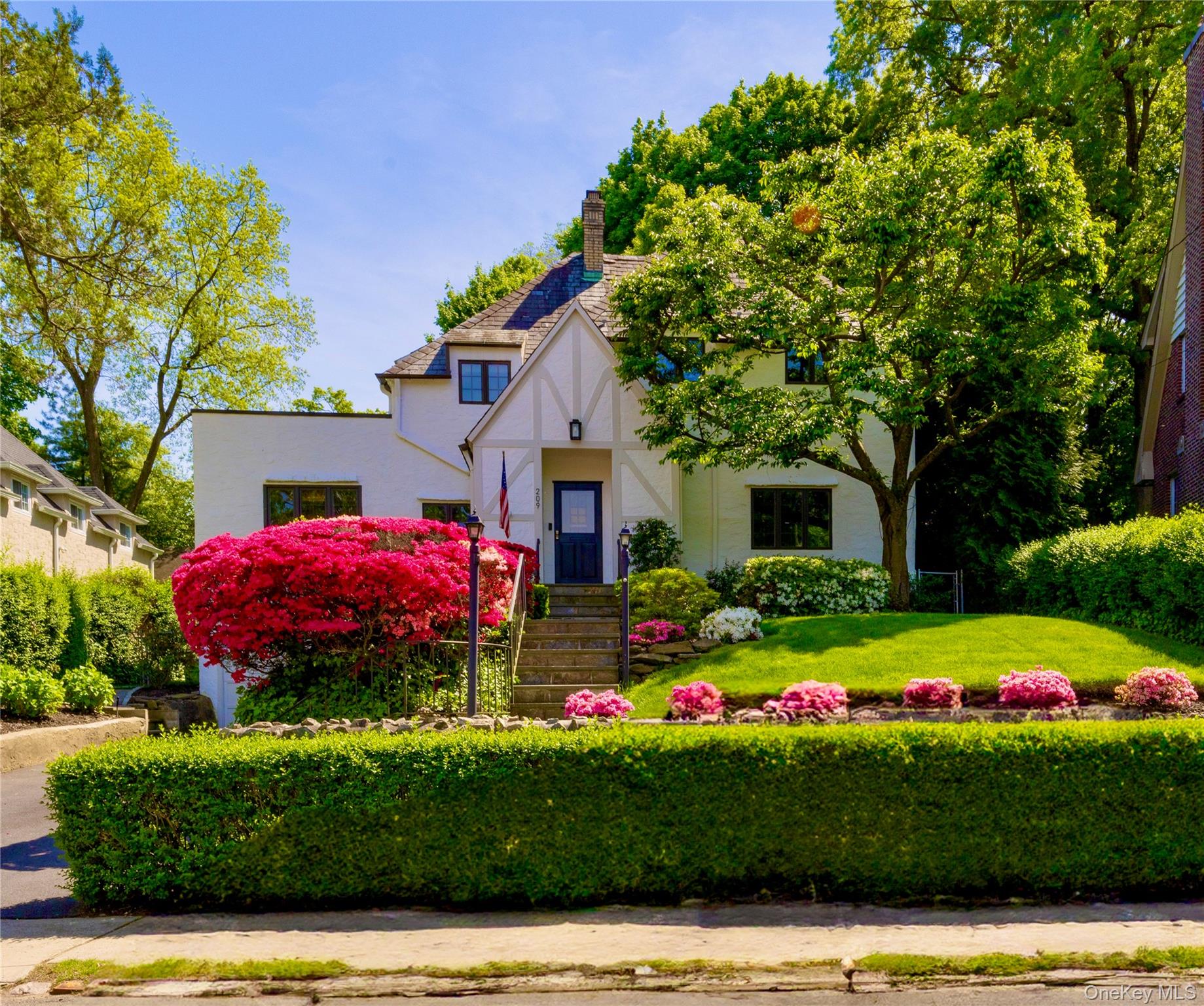 a front view of a house with a yard and fountain