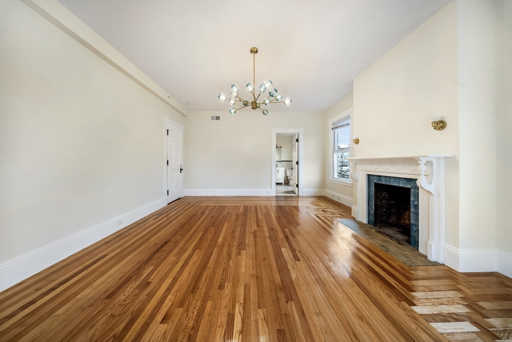 180 Jackson Street, Unit B Lawrence, MA 01841 - Photo 6 of 8 a view of a room with wooden floor and fireplace