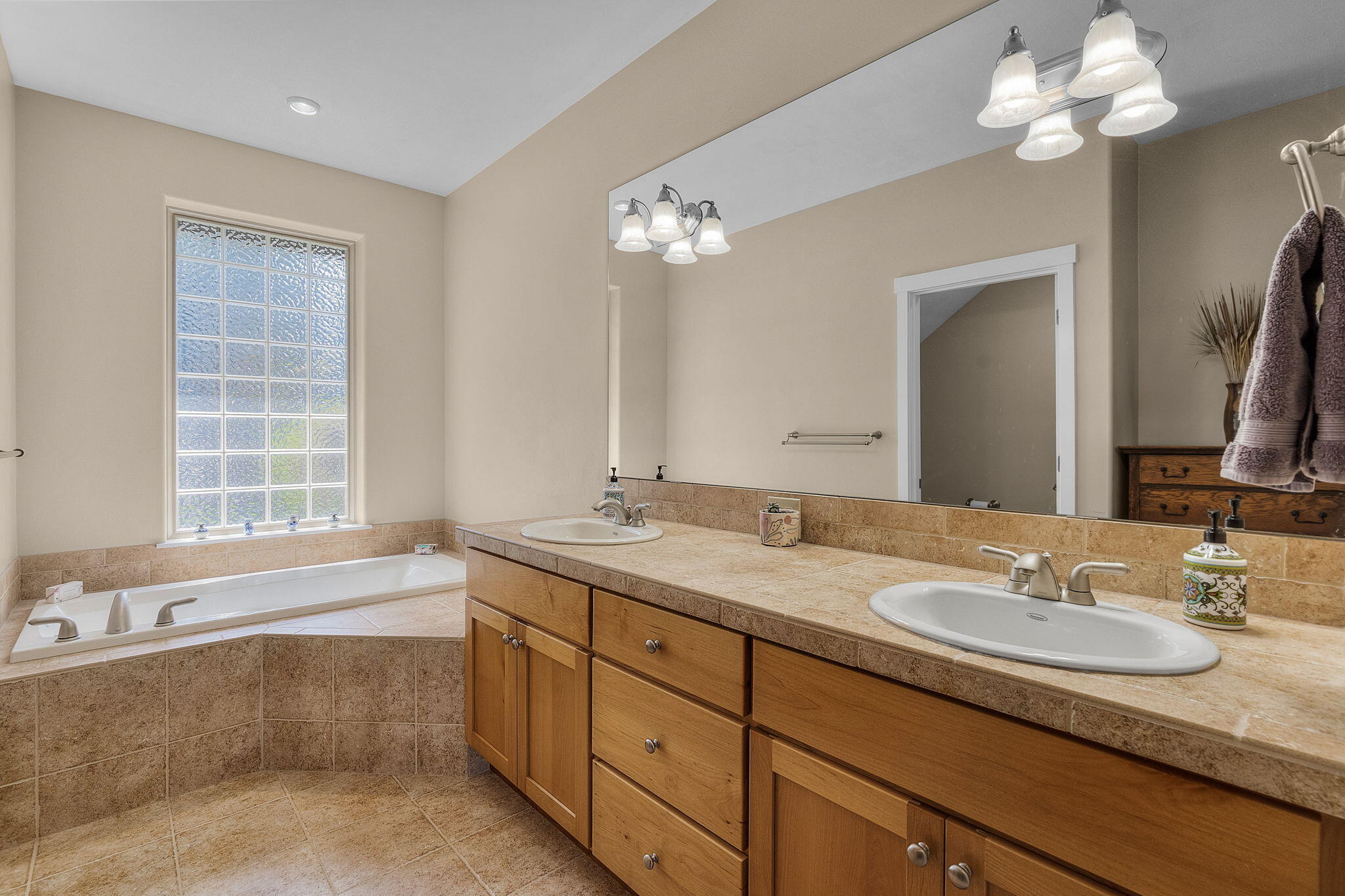 10870 Village Loop Redmond, OR 97756 - Photo 12 of 35 a bathroom with a granite countertop double vanity sink a bathtub and a window