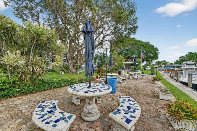 1200 Southwest 12th Court, Unit 203 Fort Lauderdale, FL 33315 - Photo 18 of 23 a view of a patio with a dining table and chairs with a garden